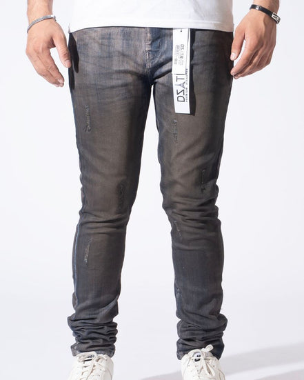 A person wearing slim-fit dark gray washed denim jeans with distressed details, paired with a white t-shirt and white sneakers, shown from the waist down against a white studio background.