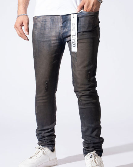 A person wearing slim-fit dark gray washed denim jeans with distressed details and white sneakers, shown from the waist down against a plain white studio background.