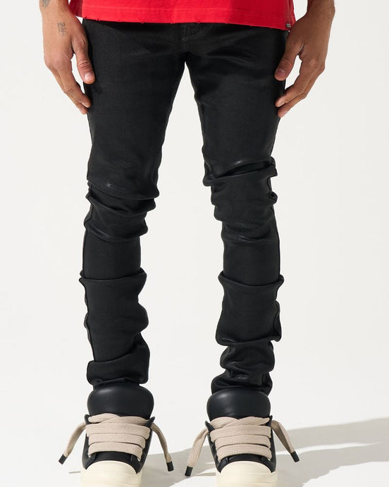 Person wearing black jeans and white sneakers on a white background