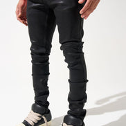 Person wearing black leather pants and white sneakers on a white background