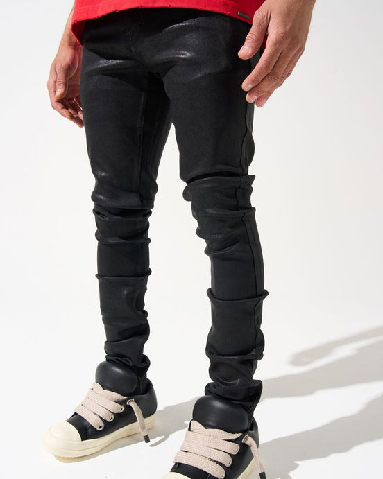 Person wearing black leather pants and white sneakers on a white background