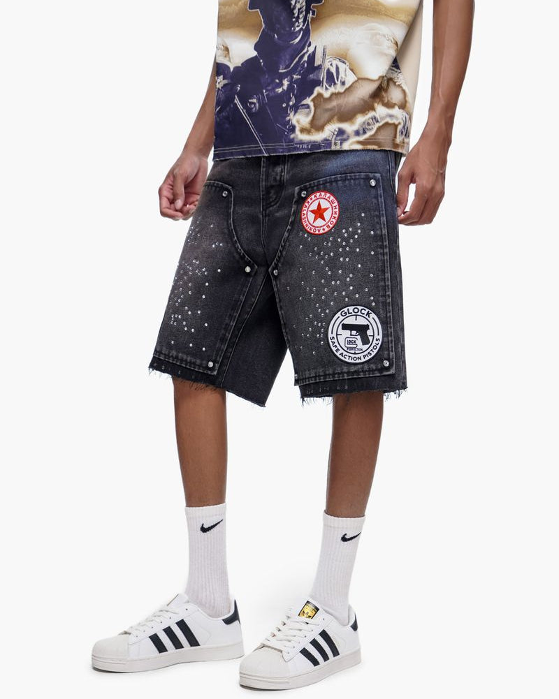 Person wearing denim shorts with patches and a graphic t-shirt on a white background