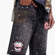 Black denim shorts with patches on a white background