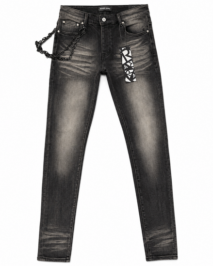 Black washed denim jeans with a decorative black chain hanging from the right pocket and a black-and-white geometric patterned patch on the left thigh, shown against a plain white background.