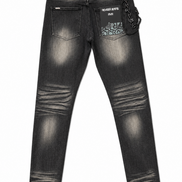 Back view of a pair of dark gray washed denim jeans with distressed fading, featuring a patterned patch pocket on the right side with the text 'NEVER KITS PACK' and a hanging chain detail.