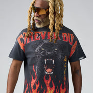 Man wearing a black t-shirt with a panther design and flames on a gray background
