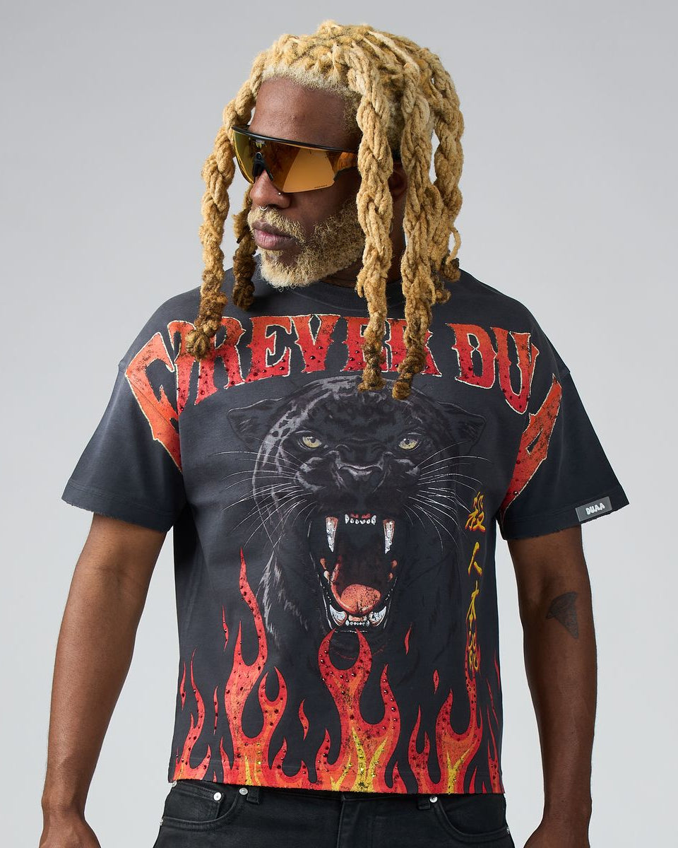 Man wearing a black t-shirt with a panther design and flames on a gray background