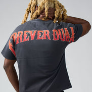 Person wearing a black t-shirt with red text on the back, standing against a plain background