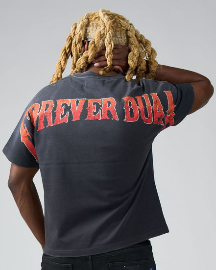Person wearing a black t-shirt with red text on the back, standing against a plain background