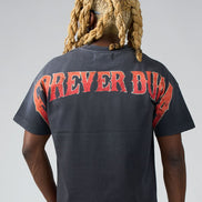 Person wearing a black t-shirt with red text on the back against a gray background