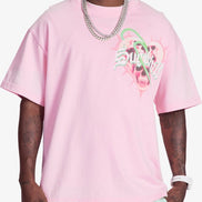 Person wearing a pink t-shirt with a graphic design on a white background