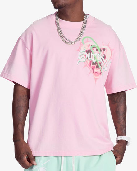 Person wearing a pink t-shirt with a graphic design on a white background