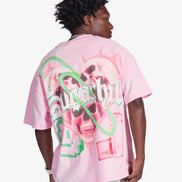 Person wearing a pink t-shirt with a graphic design on the back, standing against a white background
