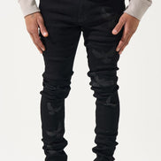 Person wearing black jeans and white sneakers on a white background