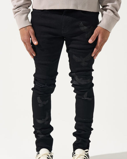 Person wearing black jeans and white sneakers on a white background