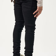 Person wearing black pants and white sneakers on a white background