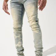 Person wearing light blue distressed jeans and white sneakers on a white background