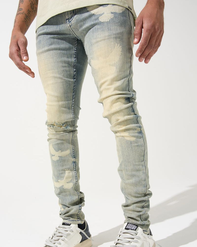 Person wearing light blue distressed jeans and white sneakers on a white background