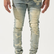 Person wearing light blue distressed jeans and white sneakers on a plain background
