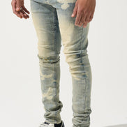 Person wearing light blue distressed jeans and white sneakers on a white background