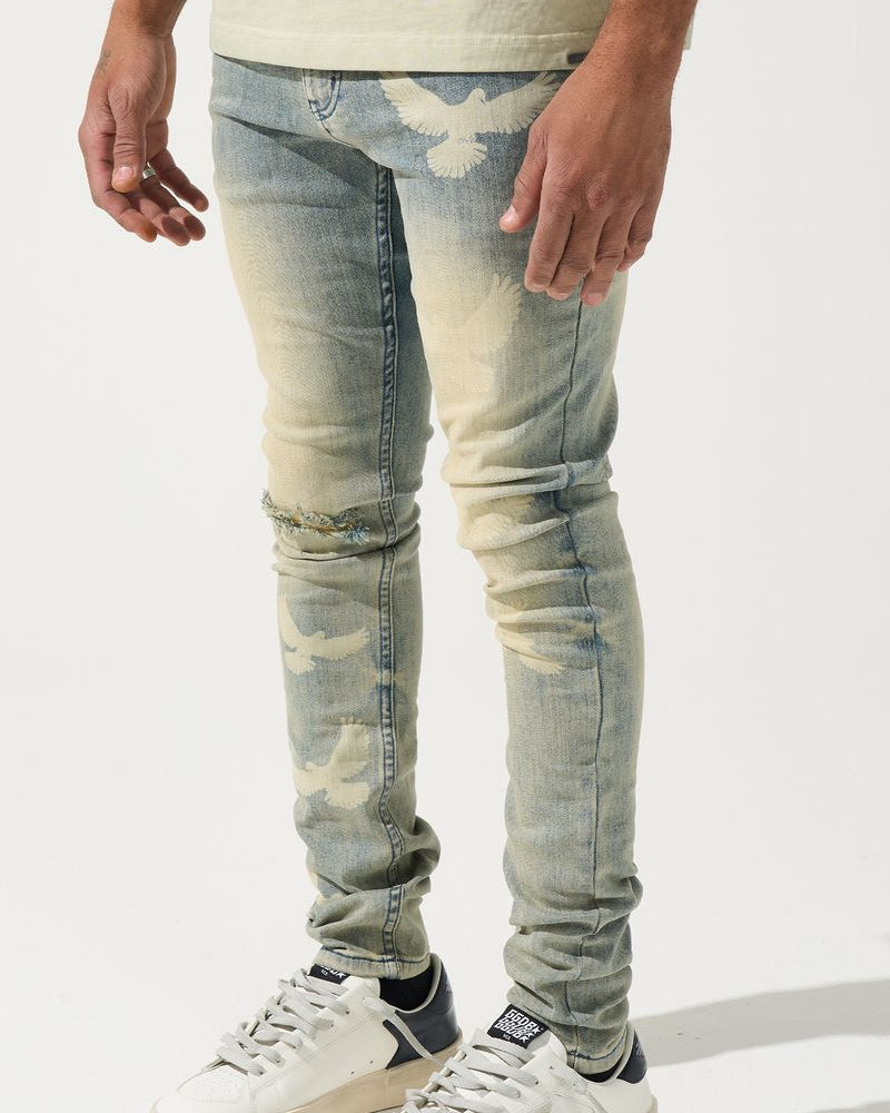 Person wearing light blue distressed jeans and white sneakers on a white background