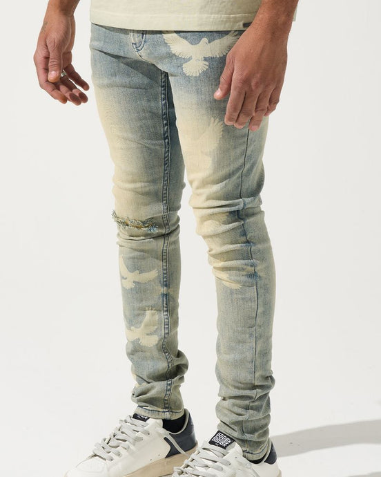 Person wearing light blue distressed jeans and white sneakers on a white background