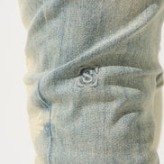 Close-up of a blue denim fabric with a brand logo.