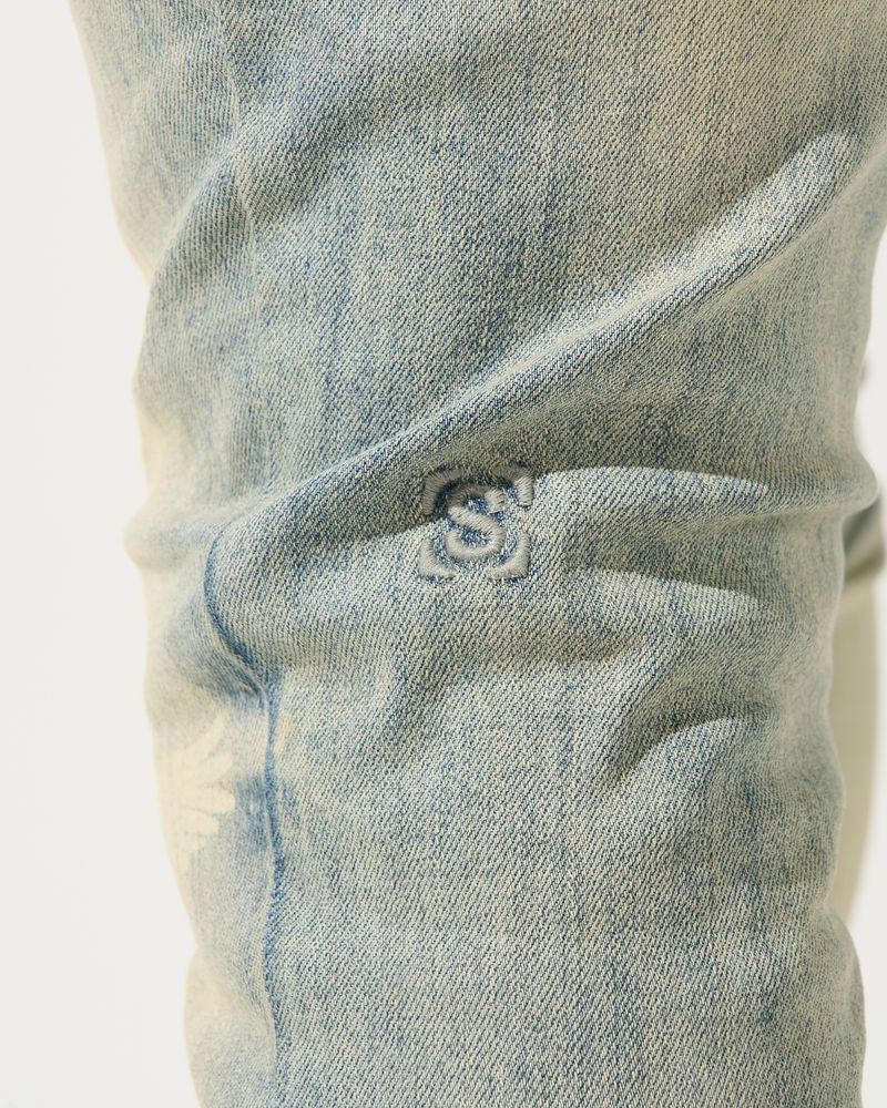Close-up of a blue denim fabric with a brand logo.