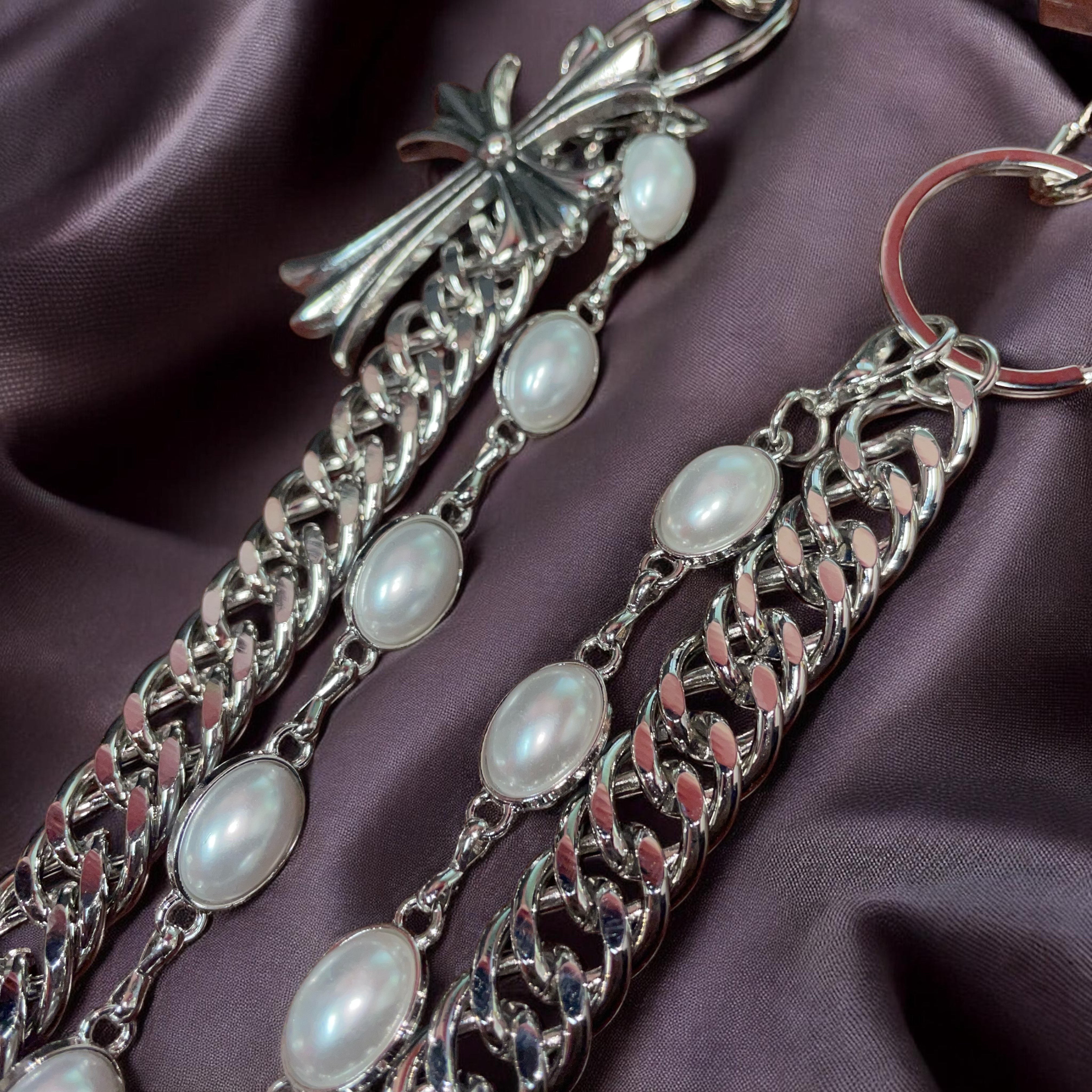 Silver WALLET chain with pearl-like beads on a purple fabric background