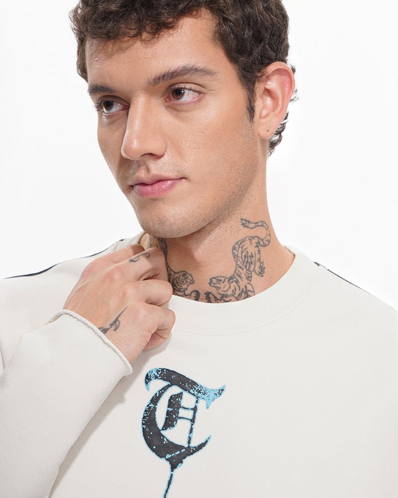 Man wearing a white sweatshirt with a black and blue graphic design on a white background