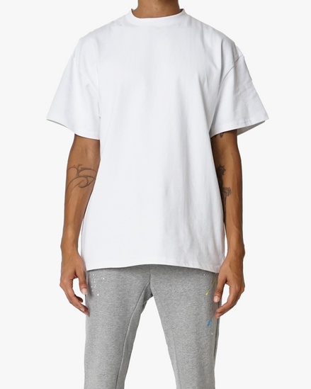 Person wearing a white t-shirt and gray pants on a white background