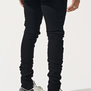 Person wearing black jeans and white sneakers on a white background