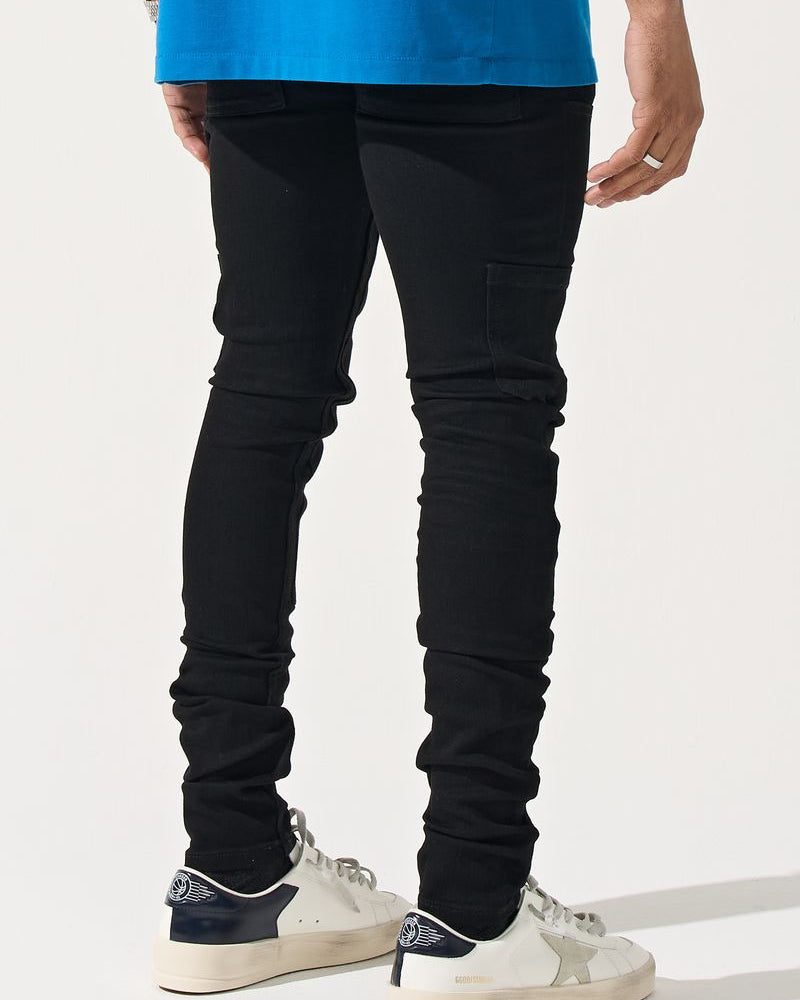 Person wearing black jeans and white sneakers on a white background