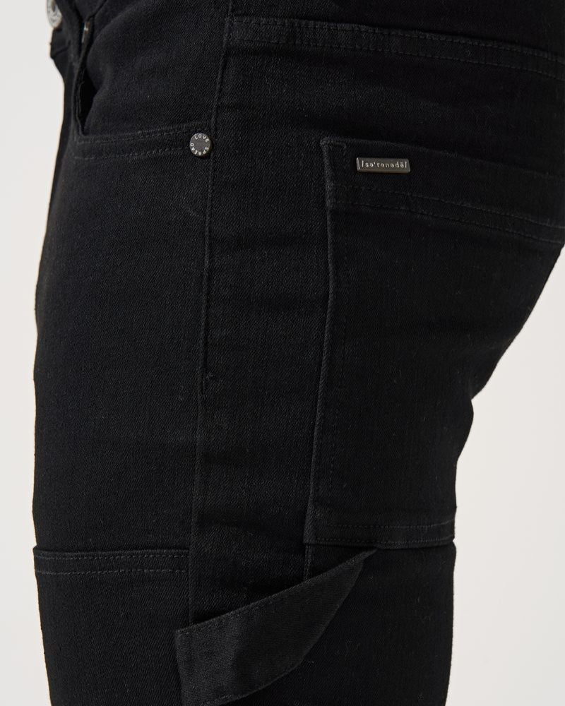 Close-up of black pants with a brand label on a white background