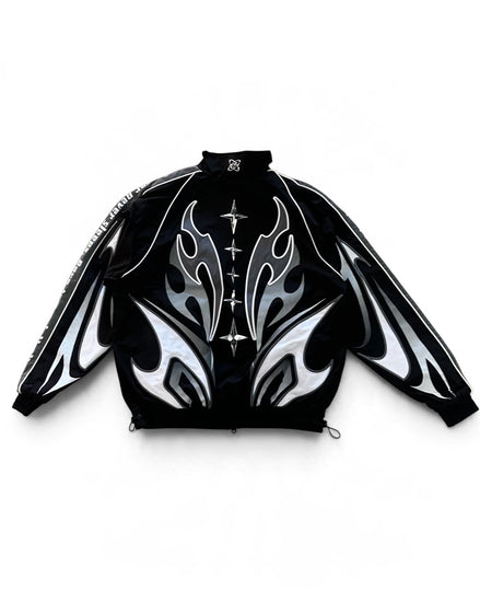 Back of A black zip-up jacket with a high collar, featuring a bold graphic design of white and silver flame-like patterns on the front and sleeves, and a decorative silver cross motif down the center front.