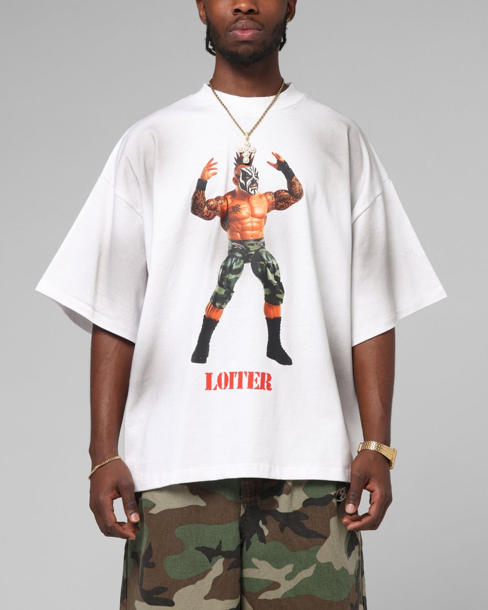 Person wearing a white t-shirt with a graphic design and text, standing against a gray background