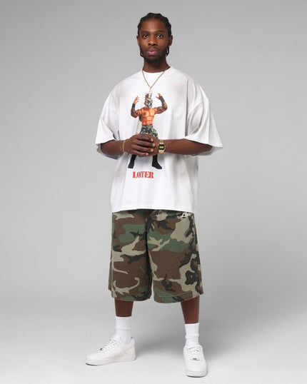 Person wearing a white t-shirt with graphic design and camouflage shorts on a gray background