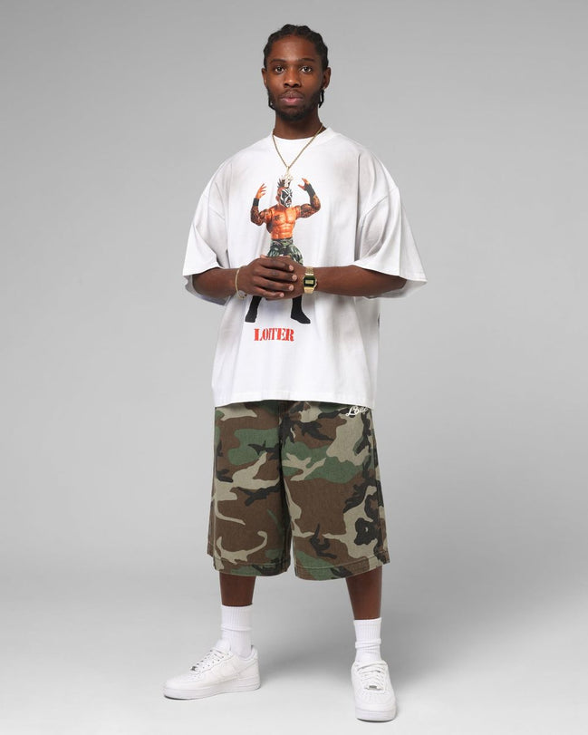 Person wearing a white t-shirt with graphic design and camouflage shorts on a gray background