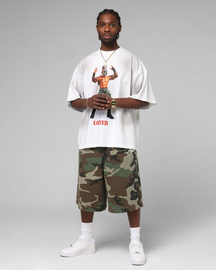 Person wearing a white t-shirt with graphic design and camouflage shorts on a gray background