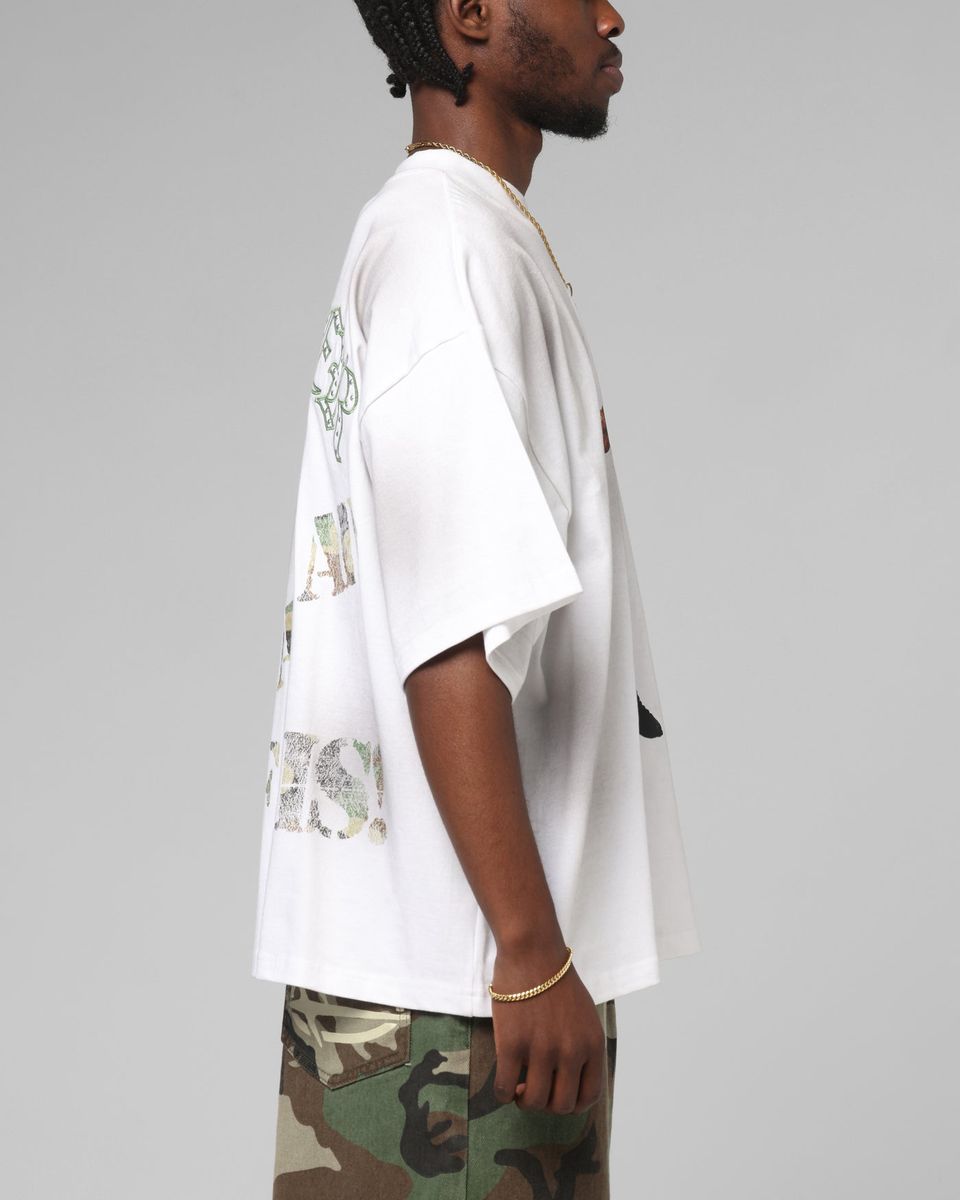 Person wearing a white shirt with camouflage pants on a gray background