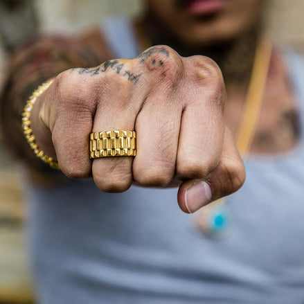 Close-up of a fist showing off the gold presidential ring with a blurred background