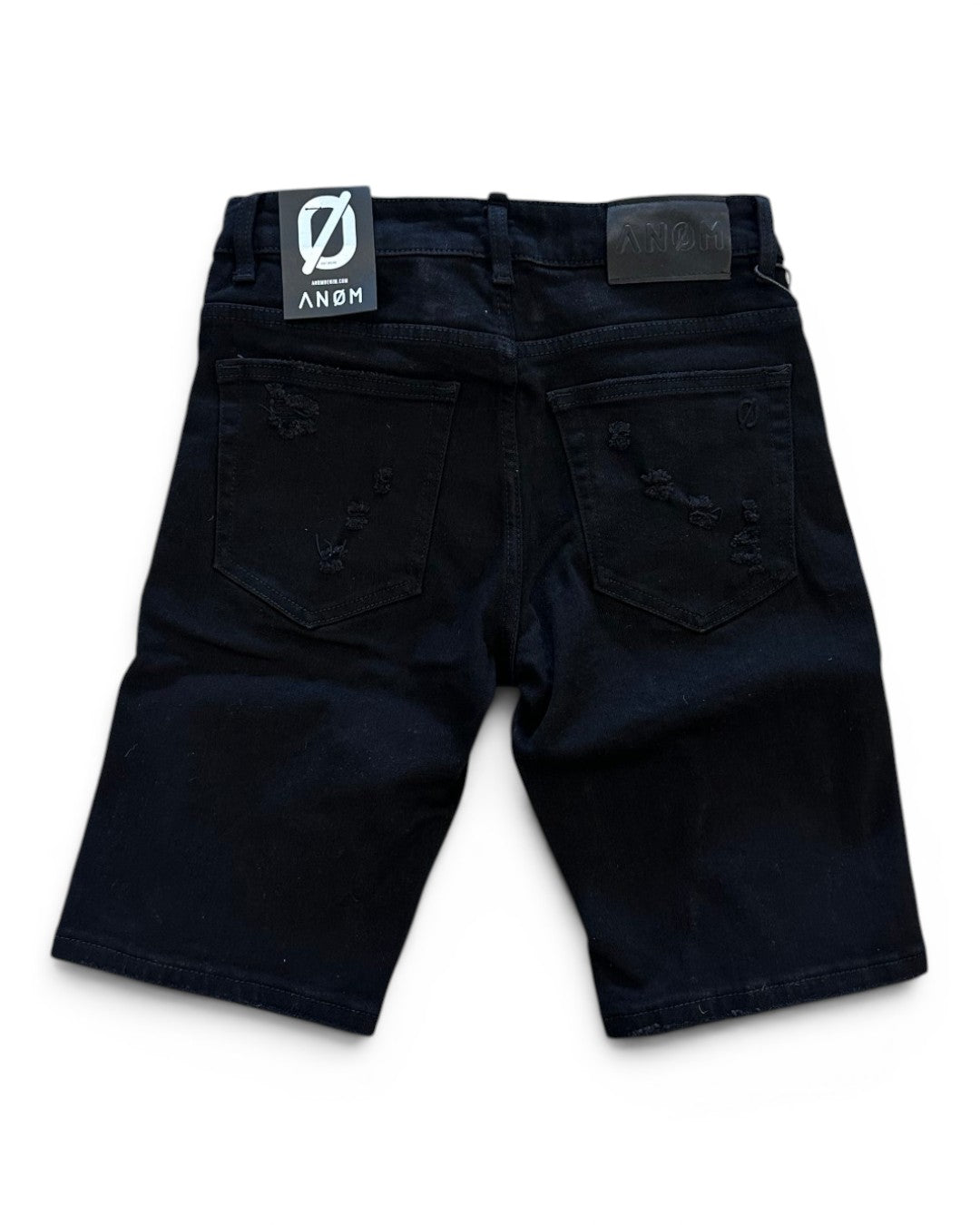 Black shorts with a brand label on a white background