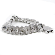 a close up of the prong cuban link bracelet  in silver on a white background