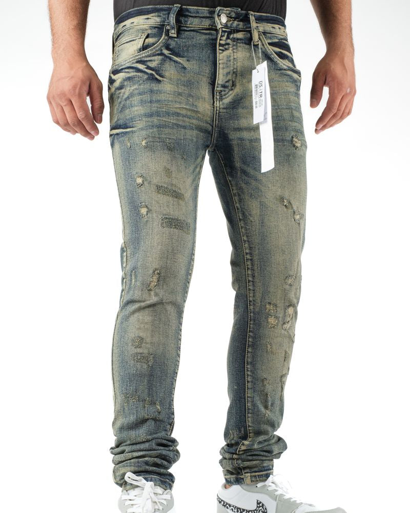 Person wearing distressed blue jeans with a visible brand tag on a white background
