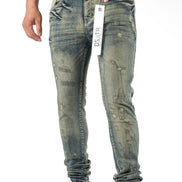 Person wearing distressed blue jeans with a visible brand tag on a white background