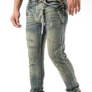 Distressed blue jeans worn by a person on a white background