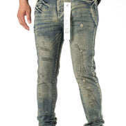 Distressed blue jeans worn by a person on a white background