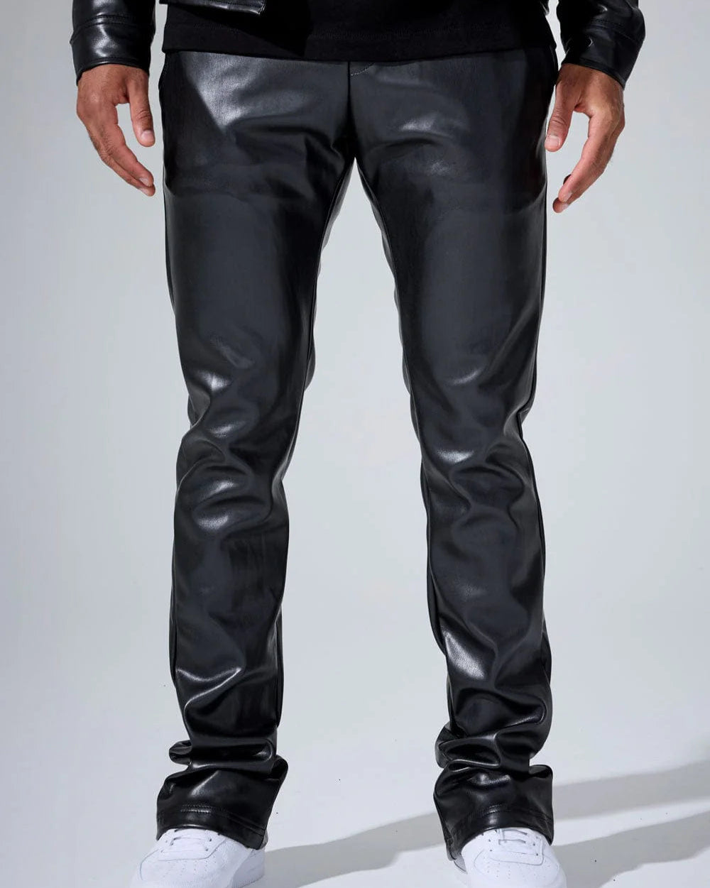 Black leather pants worn by a person on a white background