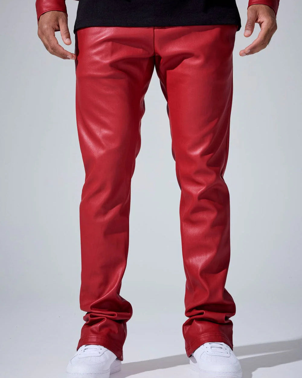 Red leather pants worn by a person on a white background