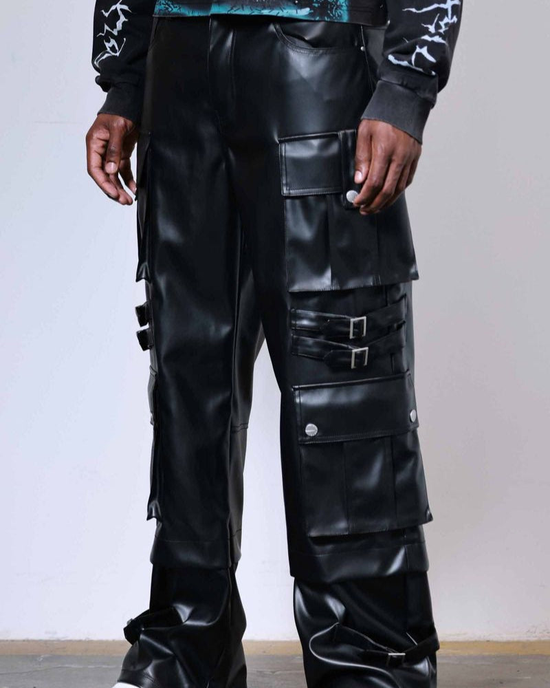 Person wearing black leather pants with multiple pockets and a white background